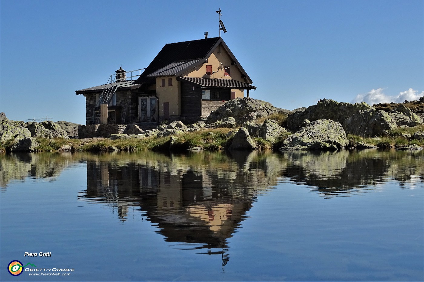 02 Il Rif. Benigni (222 m) si specchia nella grande pozza antistante.JPG